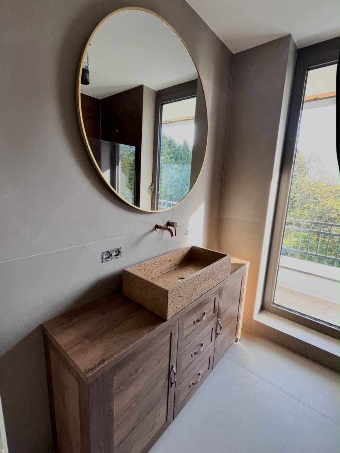 Badkamermeubel in donker hout met ronde spiegel en opbouwwastafel