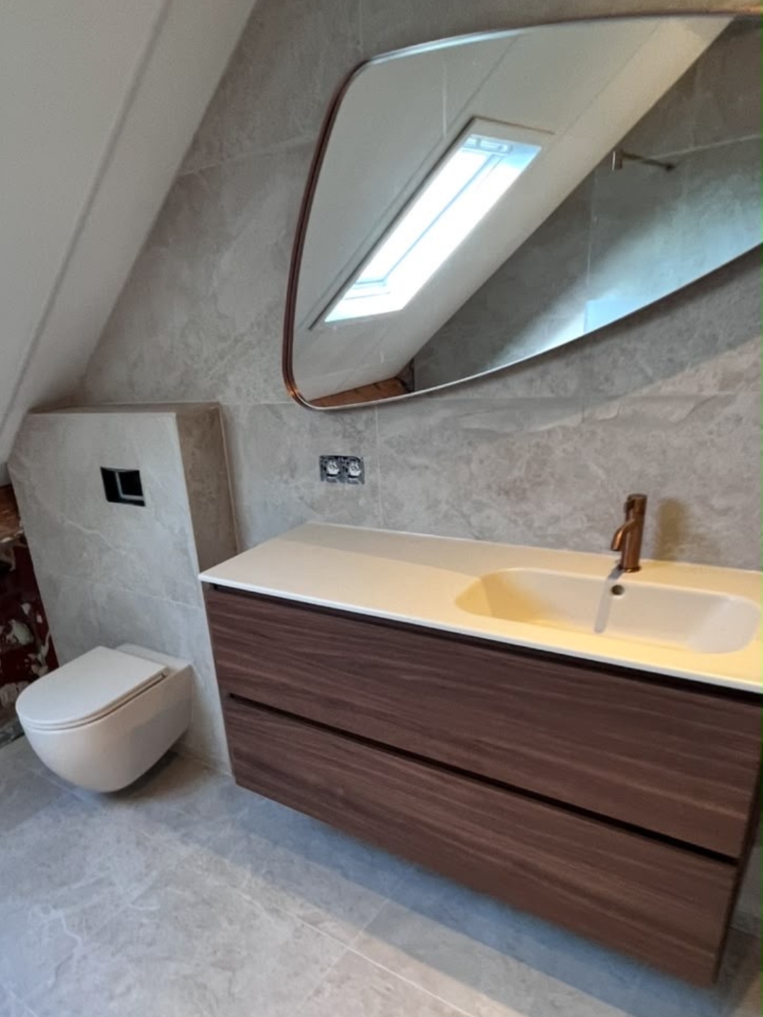 Zolderbadkamer met zwevend badkamermeubel en wandhangend toilet